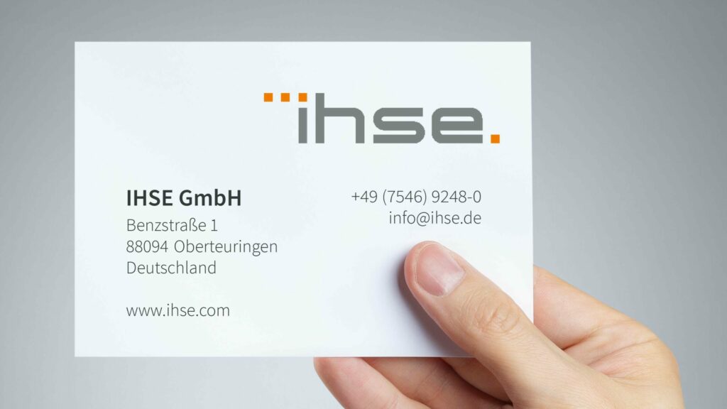 IHSE GmbH Visitenkarte in einer Hand, mit Logo in der rechten oberen Ecke und der Telefonnummer sowie Firmenadresse in Oberteuringen