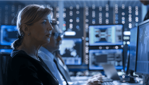 Blond woman with low ponytail and male colleague with glasses working in a control room